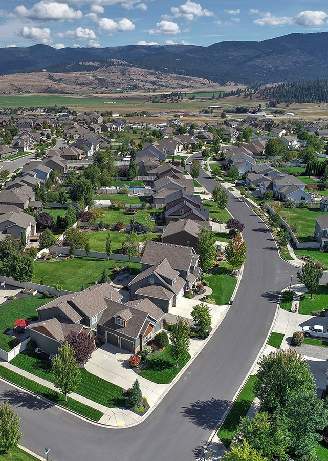 Aerial view of Spokane houses, with mountains in the background.