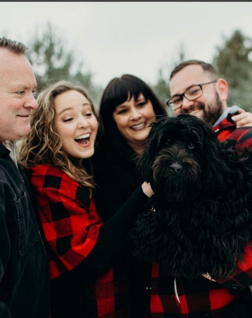 Winter photo of Amy with her family and dog.