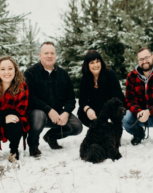 Winter photo of Amy and her family with her dog.